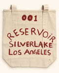 Front of the one-of-one RESERVOIR 001 hand-painted canvas tote in red lettering.
