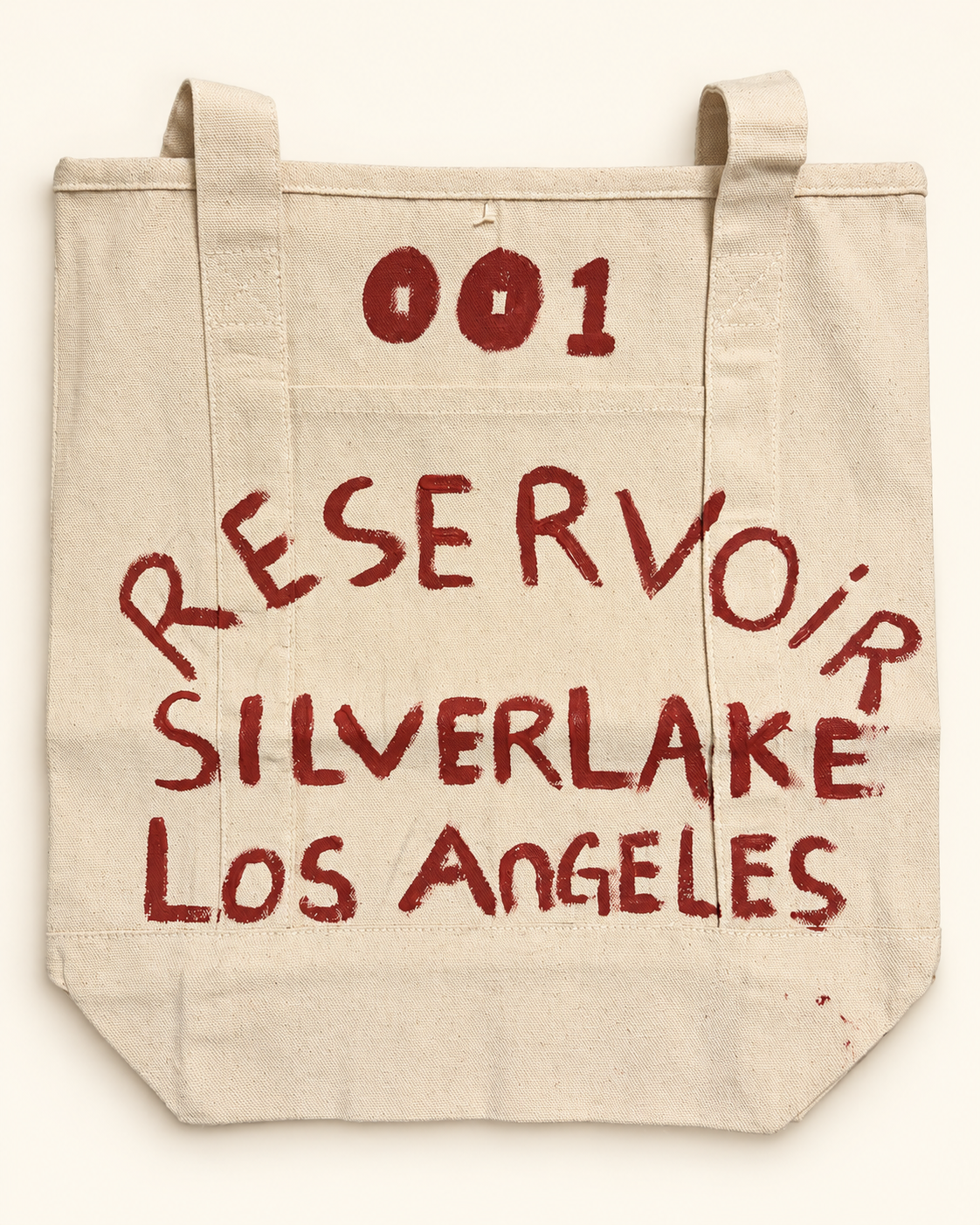 Front of the one-of-one RESERVOIR 001 hand-painted canvas tote in red lettering.